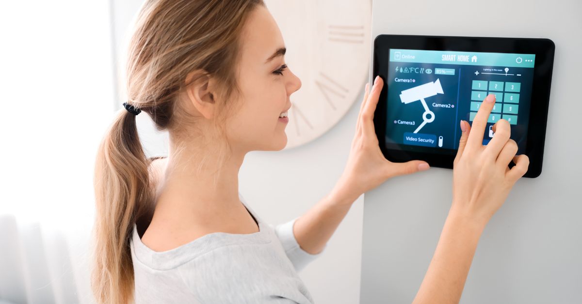 Hands touching a keypad on a Smart Home Security control panel mounted on a light-colored wall